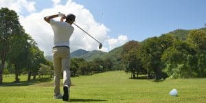 Man playing golf on a golf court on a bright sunny day