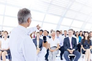 Businessmen giving a speech in front of audiences in the office