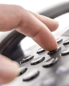 Closeup view of fingure dialing a telephone number on landline phone
