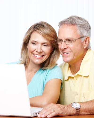 Elderly happy couple looking in the laptop screen